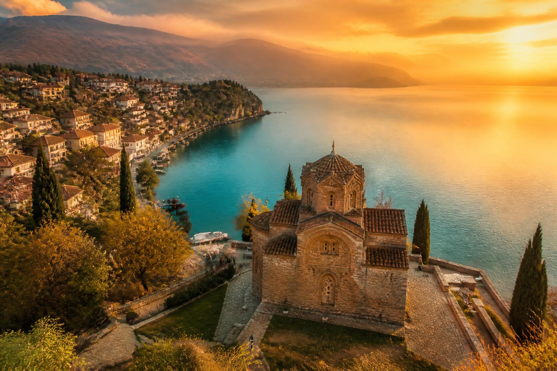Lago de Ohrid al atardecer con iglesia sobre el acantilado